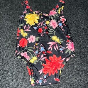 Old Navy black floral one piece bathing suit with bow accent. 0/3 months. EUC.